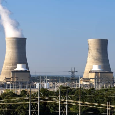 Två kärnkraftverks kylningstorn i Georgia under en blå himmel.