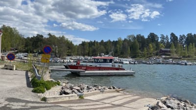 Sjöbevakningens rödvita båt vid strand.