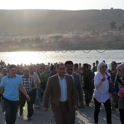 Syriska flyktingar går över gränsen till irakiska Kurdistan i Duhuk