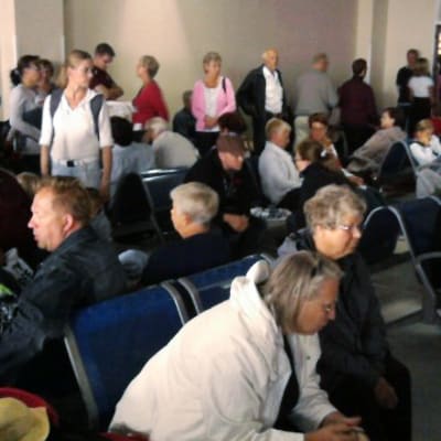 Paljon ihmisiä lentokentän odotustilassa.