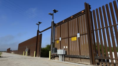 Gränsstaket och port vid Rio Grande nära McAllen i Texas