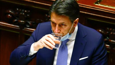  Italiens premiärmMinister Giuseppe Conte tar en klunk vatten 18.1.2021då han talar till underhuset