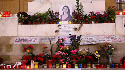 Blommor och ljus har lagts ner vid en bild på bloggaren Daphne Caruana Galizia som mördades med en bilbomb.