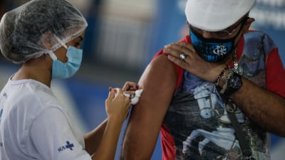 En man får en dos av Astra Zenecas coronavaccin i Brasilien