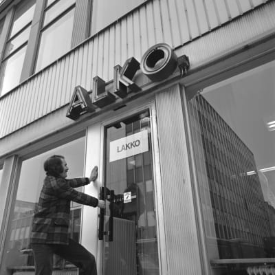 Alkon lakko 1972. Alkon lakko alkoi 24.04.1972 ja päättyi kesäkuun alussa. Alko Oy, myymälä. Ovessa lappu "Lakko". Mies yrittää avata myymälän ovea (lavastettu kuva).