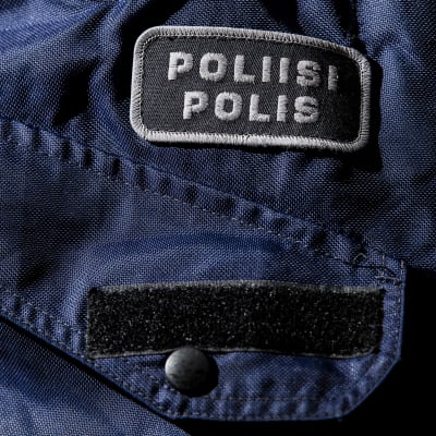 Yksityiskohta poliisin sinisessä virkapuvussa.