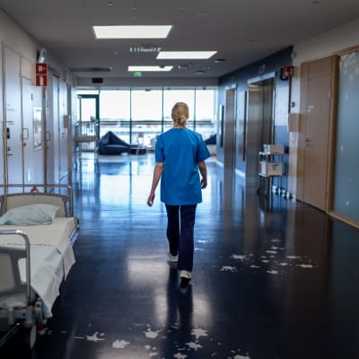 En sjukskötare går genom ett sjukhus.