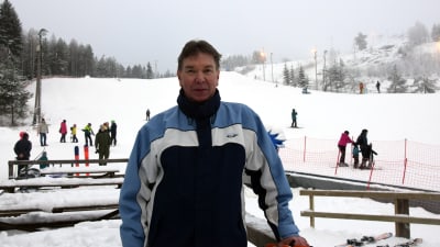 Taisto Komi poserar emd slalombacken i bakgrunden.