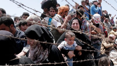 Syriska flyktingar väntar på att släppas in i Turkiet vid gränsen mellan Turkiet och Syrien.
