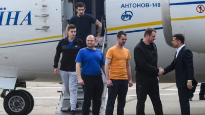 Ukrainas president Volodymyr Zelenskyj (till vänster) tog emot de frigivna ukrainska fångarna då de landade på flygplatsen i Kiev. 