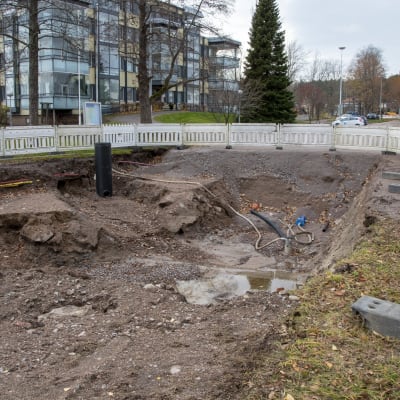 En stor grop i ändan av Tullbron i Lovisa, omringad av ett stängsel.