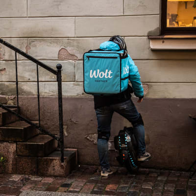 Woltbud i Helsingfors på väg in till en restaurang för att hämta mat att leverera.