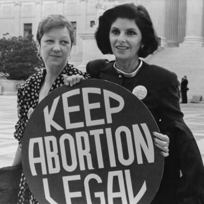 Två kvinnor bakom en skylt med texten "keep abortion legal"