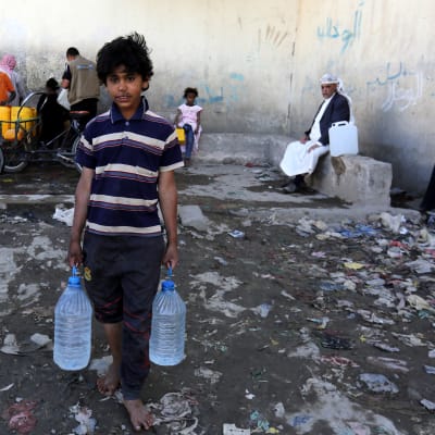 En pojke i Jemens huvudstad San'a håller två dunkar med vatten. Bristen på rent vatten är ett stort problem och har förvärrat koleraepidemin som härjar i landet.
