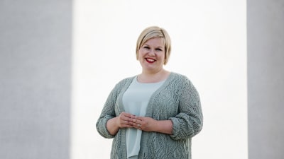 Annika Saarikko fotograferad rakt framifrån. Hon tittar in i kameran och ler.