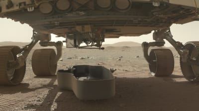 Skyddsskalet för minihelikoptern Ingenuity har lossats från rovern Perseverance på planeten Mars den 21 mars 2021. Skalet är på marken, helikoptern är fortfarande kvar i rovern.