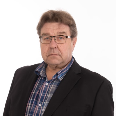 Man i glasögon mot en vit bakgrund.