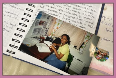 Nuoren tytön päiväkirja, jonka päällä kuva tytöstä, joka tekee läksyjään.