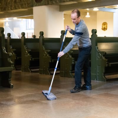 En man moppar golvet i Borgå domkyrka.
