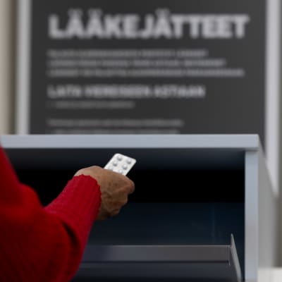 Punahihainen käsi on laittamassa lääkelevyä lääkejäteroskiin.