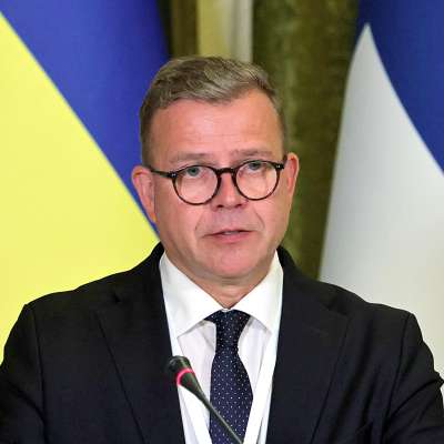 Pääministeri Petteri Orpo, taustalla Ukrainan ja Suomen liput. 