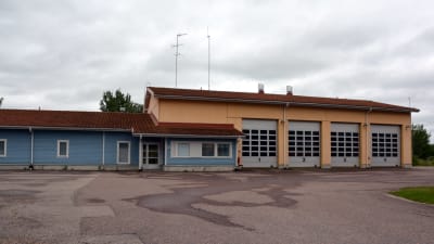 blått hus med gul garagetillbyggnad.