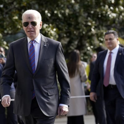 Joe Biden kävelee Valkoisen talon pihalla.