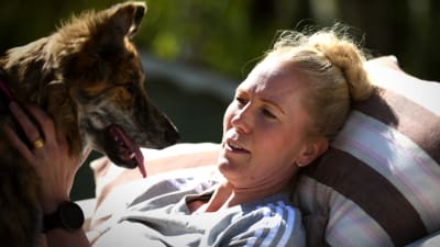 Lina ligger i hängmattanmed hunden i famnen