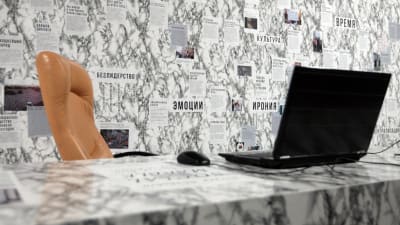 Konstinstallationen Den sociala marmorn: Civilsamhällets framväxt i Belarus. På bilden en stol, en dator och en vägg med tidningsurklipp.