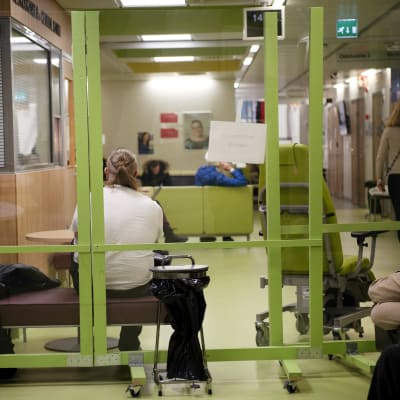 Ihmiset istuvat päivystyksen odotusaulassa.