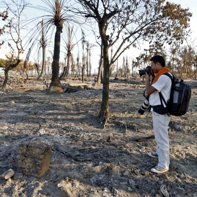 Fotograf tar bild av nerbränd rohingyaby i västra Burma.
