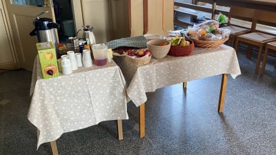 Ett bord med kaffe, frukt och bröd på inne i en kyrka.
