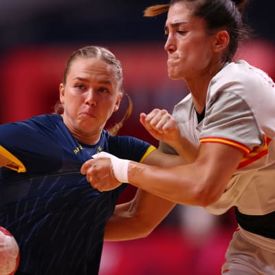 Sveriges Jenny Carlson håller i bollen och kämpar mot en motståndare i premiärmatchen mot Spanien i OS i Tokyo.