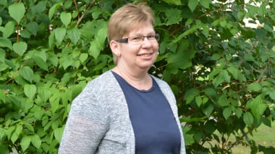 Personporträtt på en kvinna i en grön trädgård.