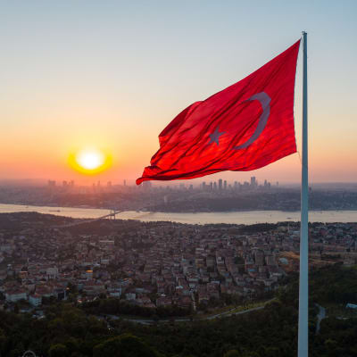 Turkin lippu liehuu tangossa. Taustalla näkyy Istanbul ja Bosporinsalmi.