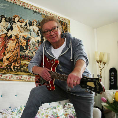Kisu Jernström poserar i sitt hem i Degerby med en Hagström Viking gitarr