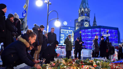 Blommor och ljus vid julmarknaden i Berlin där 12 människor dog i ett terrorattentat.