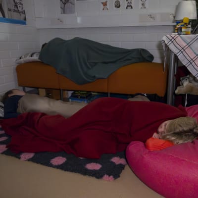 Kolme poikaa nukkumassa päiväunia kasvatusohjaajan huoneessa kesken koulupäivän.