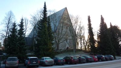 Lojos kyrka syns bakom träden vid Kyrkogatan.