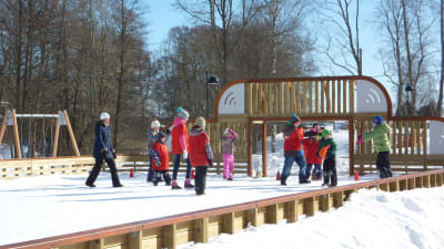 Skolbarn leker ute på vintern.