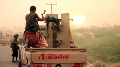 En man avfyrar ett tungt maskingvär i Jemen. 
