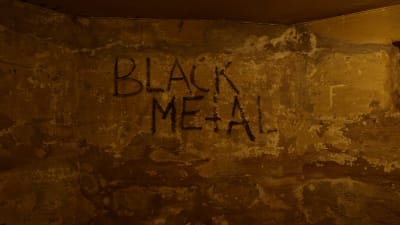 Texten "Black Metal" som graffitti på en vägg i en källare