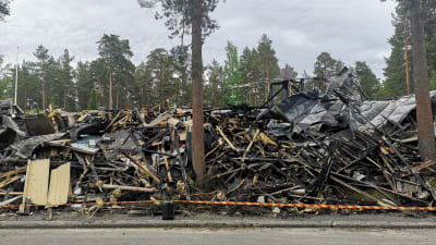 bild på hög med bränt trä och saker som brunnit upp i en brand i en radhuslänga. 