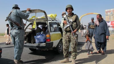 Soldater söker igenom en bil som användes av en familj på flykt undan strider i Sangin i Helmand-provinsen i södra Afghanistan.