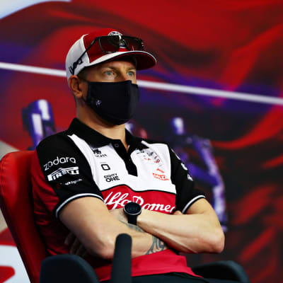 Kimi Räikkönen sitter med armarna i kors på en presskonferens. 