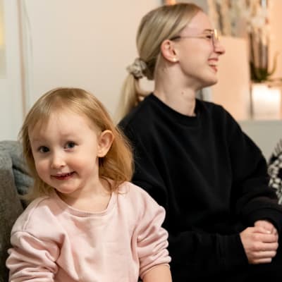 Yrittäjä Anniina Saksanen istuu sohvalla tyttärensä Elsan kanssa.