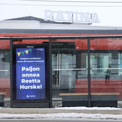 Onnitteluviesti aituri Reetta Hurskeelle bussipysäkin mainostaulussa Tampereella.