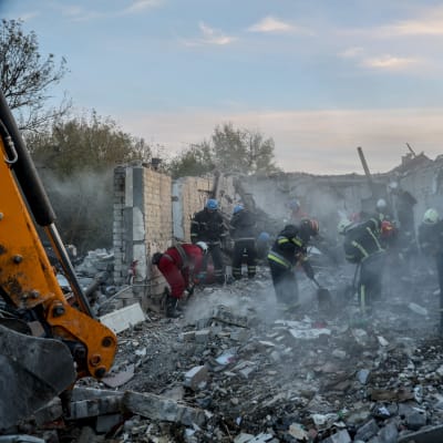 Brandmän gräver igenom rasmassor efter rysk robotattack.