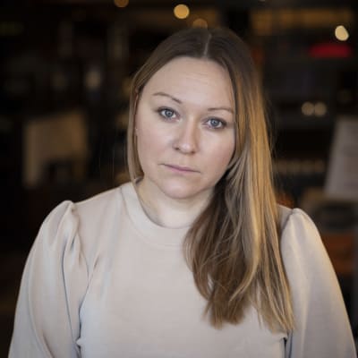 Kvinna i beige tröja.