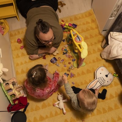 Sami Halttunen leikkii lastensa Myyn ja Sisun kanssa lasteenhuoneessa.